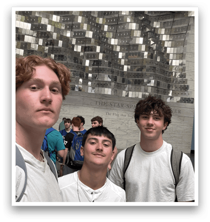 Three young men in white shirts pose for a picture in front of a large mirror. AI generated content