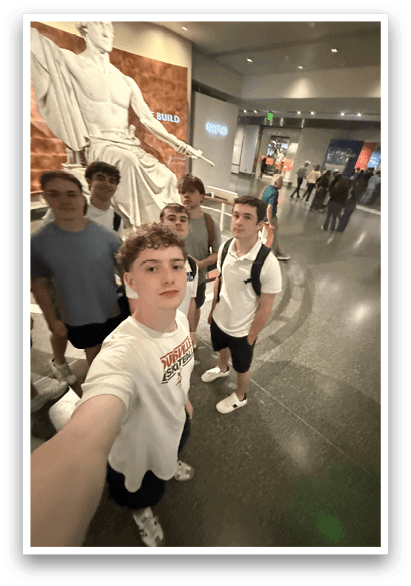 A group of young men pose for a picture in front of a statue. AI generated content