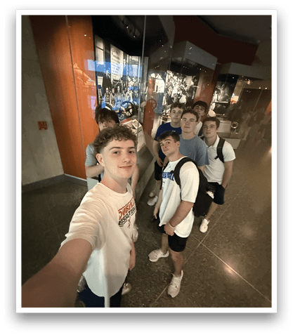 A group of young men pose for a picture in front of a museum display. AI generated content