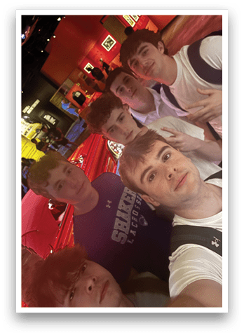 A group of young men pose for a picture in front of a red wall. AI generated content
