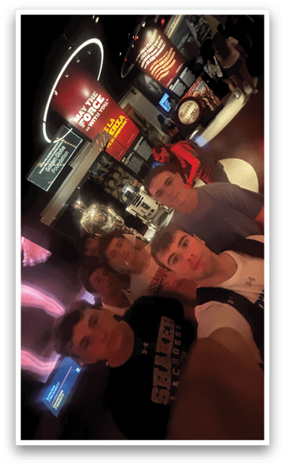 Five young men pose for a photo in front of a museum display. AI generated content