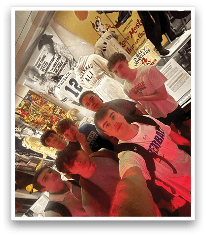 A group of young men pose for a picture in front of a sports memorabilia display. AI generated content