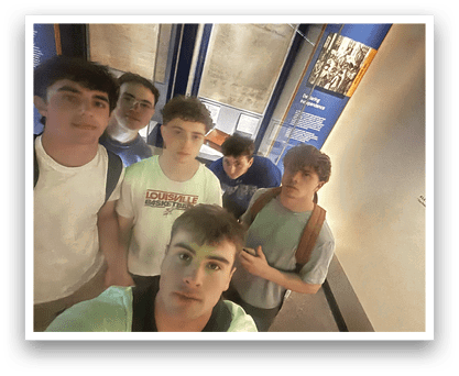 Five young men pose for a picture in front of a museum display. AI generated content
