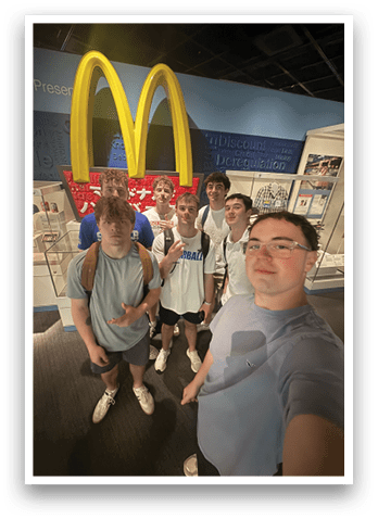 A group of young men pose in front of a Mcdonald's sign. AI generated content