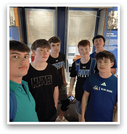 A group of five young men pose for a picture in front of a display case. AI generated content