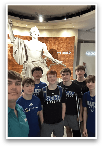 A group of young men pose for a picture in front of a statue. AI generated content