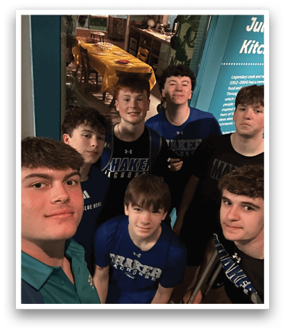 A group of young men wearing blue shirts and black shorts pose for a picture. AI generated content