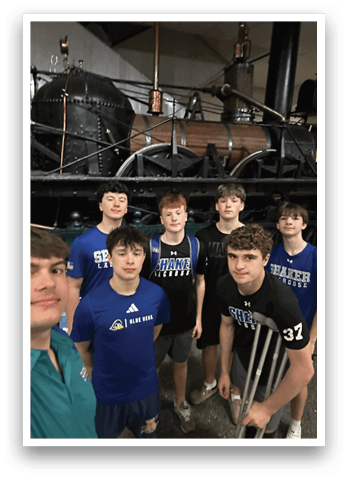 A group of young men pose for a picture in front of a steam engine. AI generated content