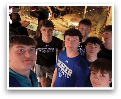 A group of young men pose for a photo in front of a museum exhibit. AI generated content