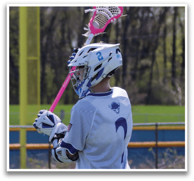 A man holding a pink and white lacrosse stick. AI generated content