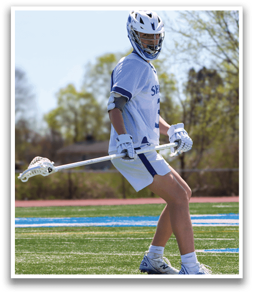 A man wearing a white and blue uniform is holding a lacrosse stick and standing on a field. AI generated content