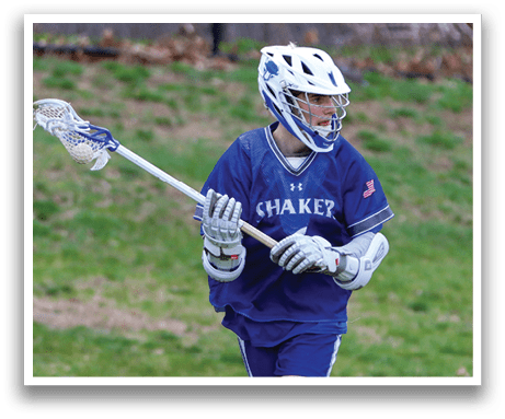 A young man wearing a blue and white uniform is holding a lacrosse stick and running on a grassy field. AI generated content