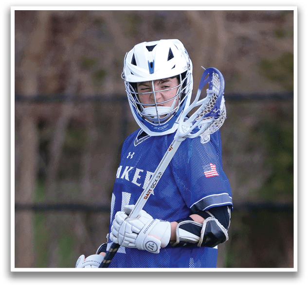A young man wearing a blue and white lacrosse uniform is holding a lacrosse stick and walking on a grassy field. AI generated content