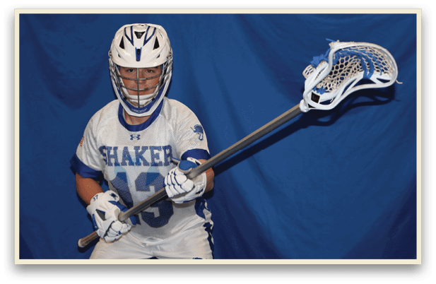 A young man wearing a white and blue jersey holds a lacrosse stick. AI generated content