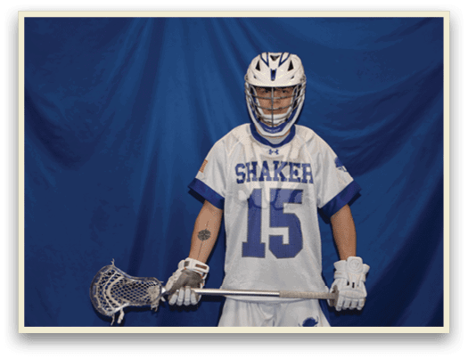 A man wearing a white and blue jersey with the number 15 stands in front of a blue curtain holding a lacrosse stick. AI generated content
