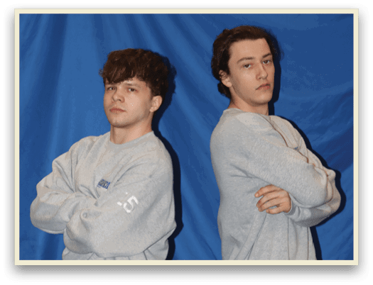 Two young men pose for a picture in matching grey sweatsuits. AI generated content