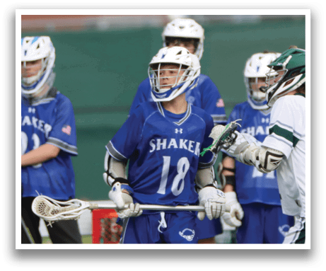 Two lacrosse players are on the field, one wearing a blue uniform and the other wearing a white uniform. They are both holding lacrosse sticks and appear to be in the middle of a game. AI generated content