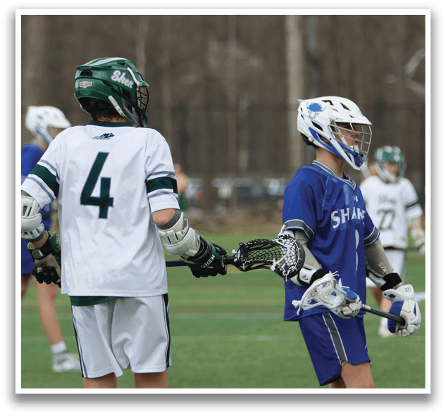 Two young men wearing helmets and holding lacrosse sticks are standing on a field. AI generated content