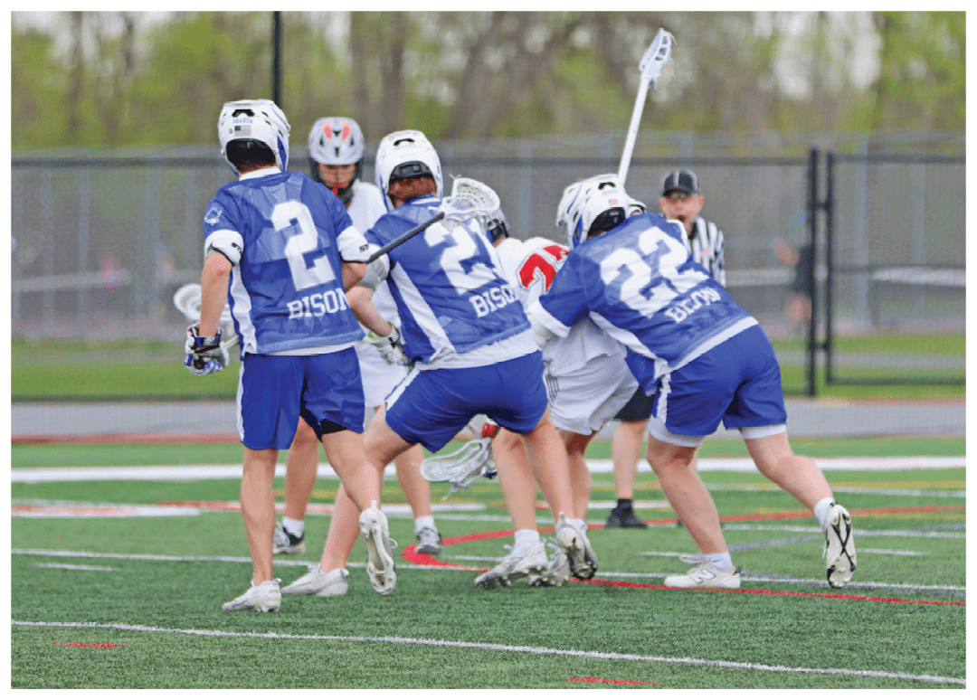 A group of people playing a game of lacrosse. Description generated by AI