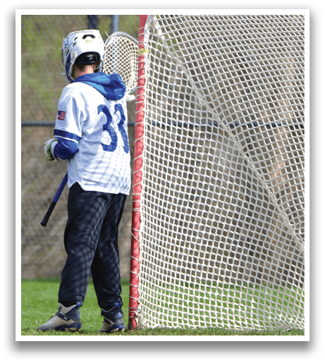 A person wearing a white and blue shirt is standing in front of a net. Description generated by AI