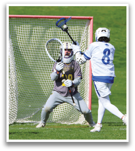 A man wearing a grey shirt and white pants is playing lacrosse. Description generated by AI