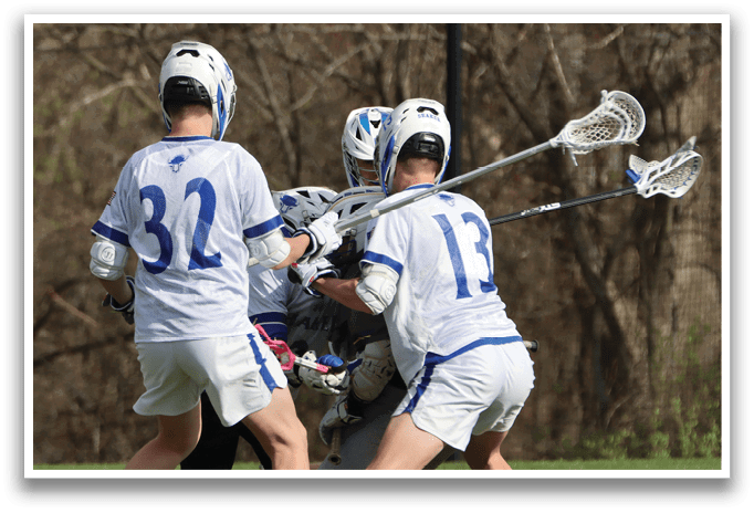 A group of men playing lacrosse on a field. Description generated by AI