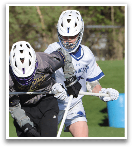Two people playing lacrosse on a field. Description generated by AI