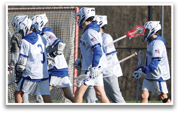 A group of young men wearing white and blue uniforms are walking on a field. Description generated by AI
