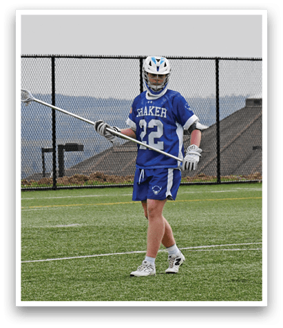 A man holding a lacrosse stick on a field. Description generated by AI