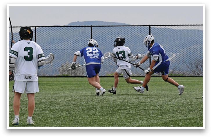 A group of men playing lacrosse on a field. Description generated by AI