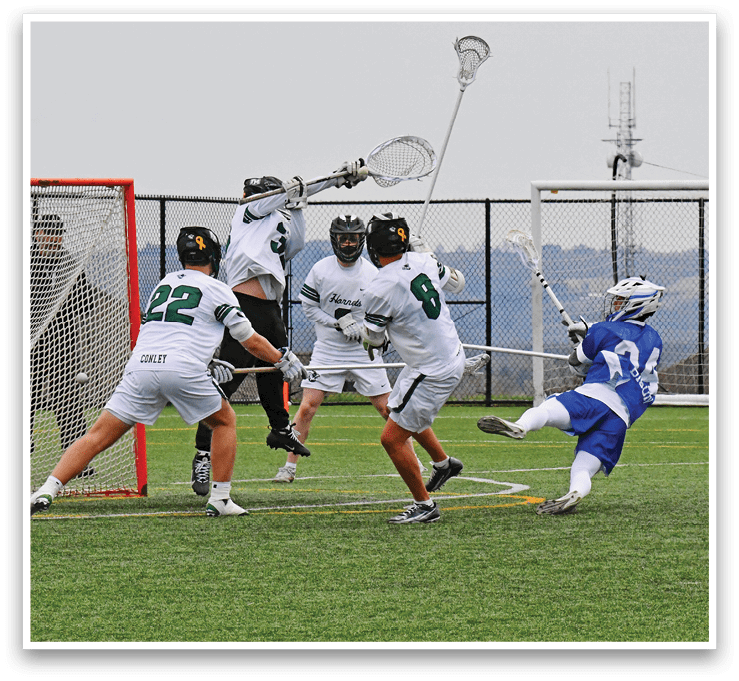 A group of men playing lacrosse on a field. Description generated by AI