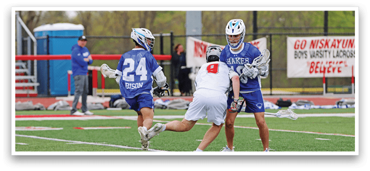 A group of people playing a game of lacrosse. Description generated by AI