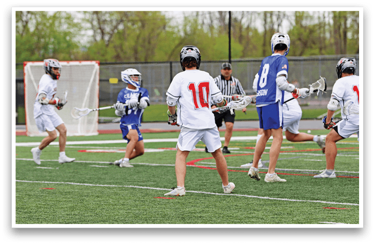A group of men playing lacrosse on a field. Description generated by AI