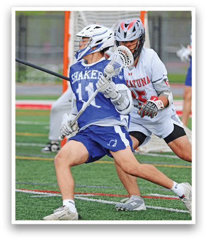 A man wearing a blue and white uniform is holding a lacrosse stick. Description generated by AI