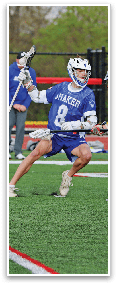 Two men playing lacrosse on a field. Description generated by AI