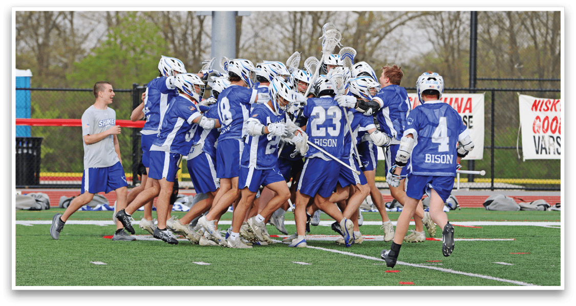 A group of people wearing blue and white uniforms are celebrating on a field. Description generated by AI