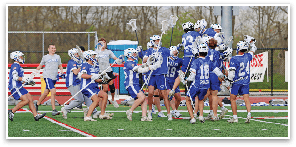 A group of people wearing blue and white uniforms are celebrating on a field. Description generated by AI