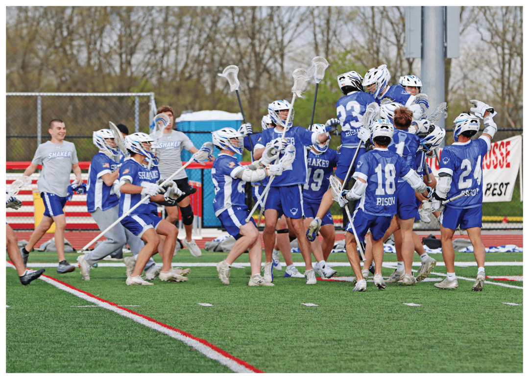 A group of people wearing blue and white uniforms are celebrating on a field. Description generated by AI