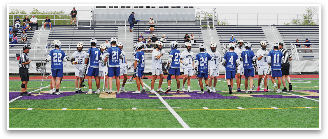 A group of people standing on a field with blue and white uniforms. Description generated by AI