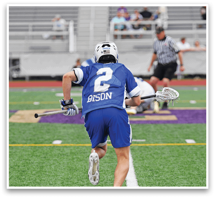A man wearing a blue jersey with the number 2 on it is running on a field. Description generated by AI