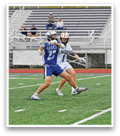A man in a blue and white uniform is running with a lacrosse stick. Description generated by AI