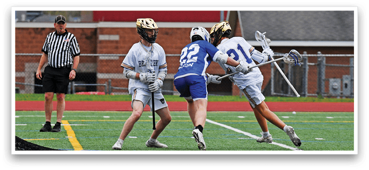 A group of people playing lacrosse on a field. Description generated by AI