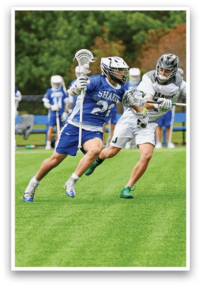 A group of men playing lacrosse on a field. Description generated by AI
