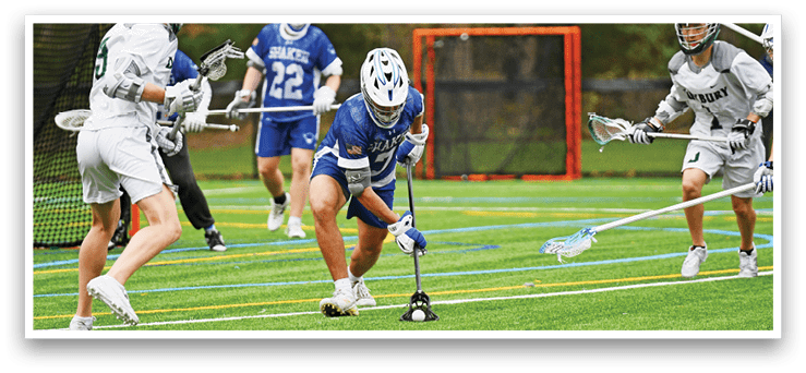 A group of people playing lacrosse on a field. Description generated by AI