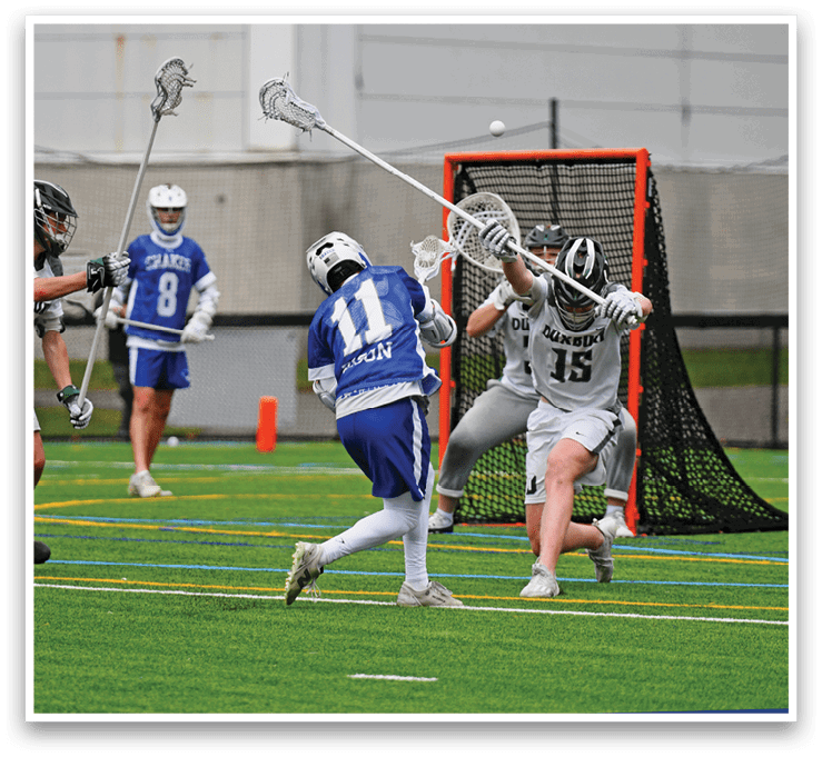 A group of people playing lacrosse on a field. Description generated by AI