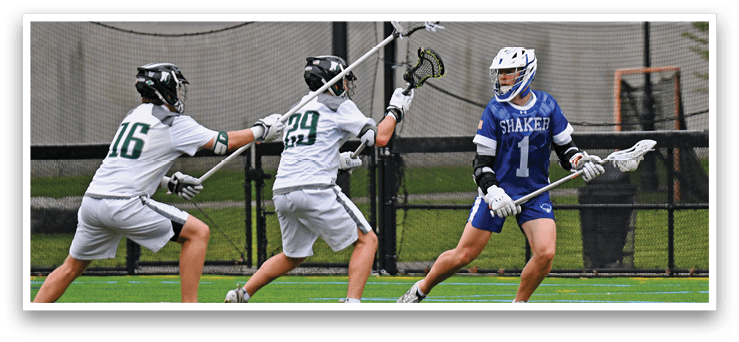 A group of men playing lacrosse on a field. Description generated by AI