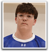 A young man wearing a blue and white shaker jersey. Description generated by AI