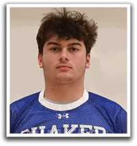 A young man wearing a blue and white shaker jersey. Description generated by AI
