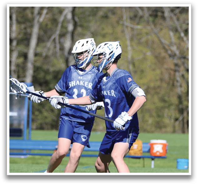 Two boys playing lacrosse. Description generated by AI