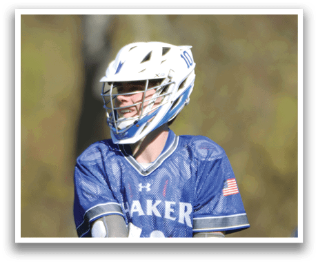 A man wearing a blue and white shirt and holding a lacrosse stick. Description generated by AI